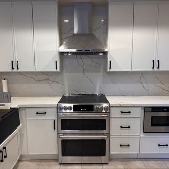 Range, microwave drawer, quartz backsplash. Toe-kick drawers installed below microwave.